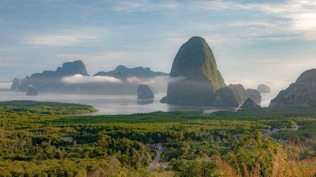 Limestone islands rising out of misty water seen from the Ao To Li viewpoint in Phang Nga
