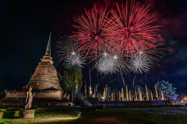 Fireworks over a lit chedi during the Loi Krathong festival in Sukhothai